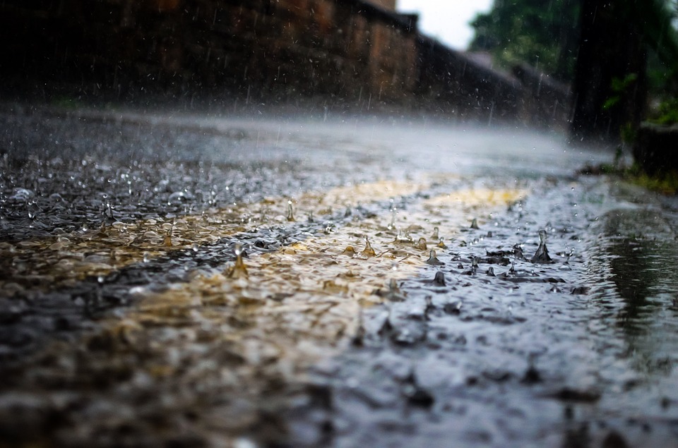 Rain hitting the road on a cloudy, rainy day.