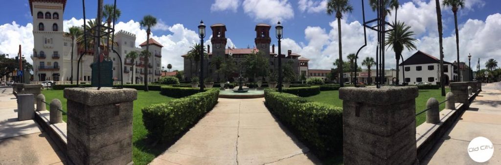 Image contains a large building and lush grounds.