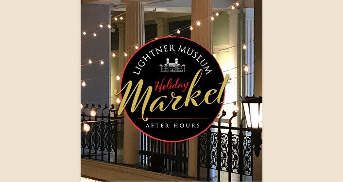 image at night time of building with strings of white lights, round sign in forefront with Lightner Museum After Hours Holiday Market