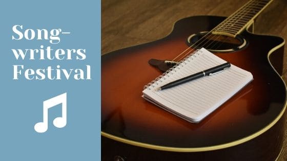 Image contains a guitar with a notepad and pen on top of it.