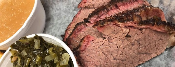 Image contains a plate of brisket and two sides.