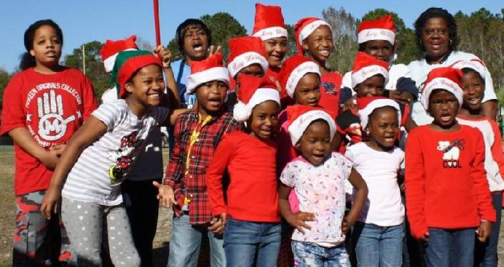 group of kids wearing Santa hats watching the Hastings Hometown Christmas Parade
