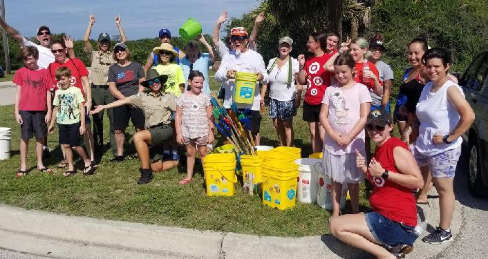 image of men and women and children standing with buckets after Anastasia State Park Coastal Cleanup