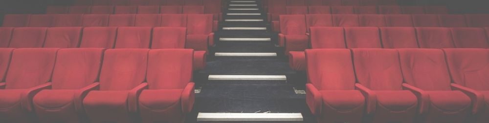 Four rows of theater seats with a staircase dividing them.